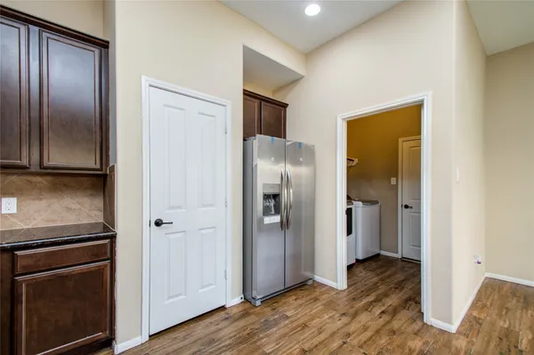 a view of a livingroom with wooden floor kitchen and bathroom