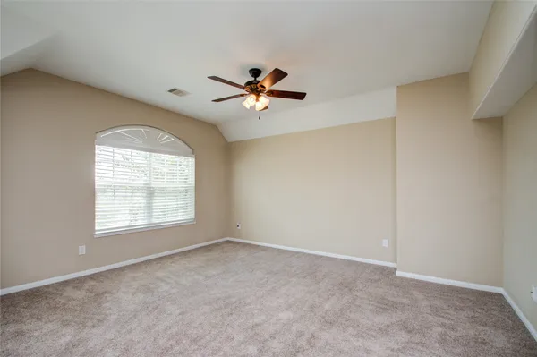an empty room with a window and a ceiling fan
