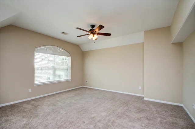 an empty room with a window and a ceiling fan