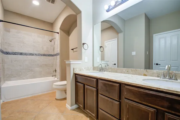 a bathroom with a double vanity sink toilet mirror and bathtub