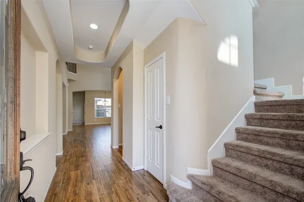 a view of a hallway with wooden floor and entryway