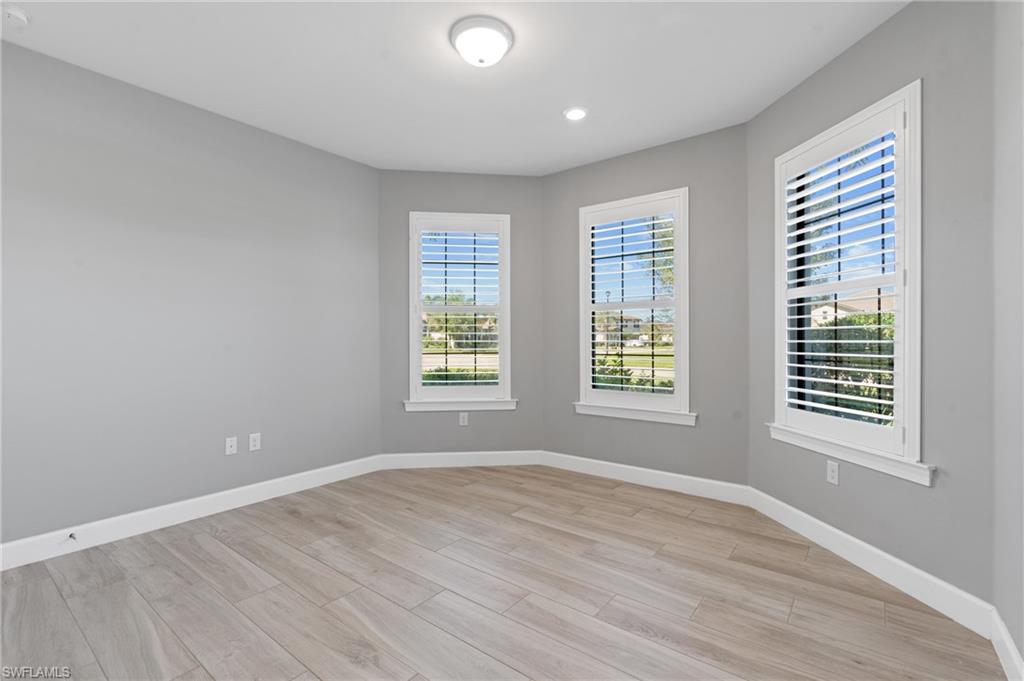 19953 Beverly Park Road Estero, FL 33928 - Photo 14 of 50 Empty room featuring light wood-style flooring and baseboards