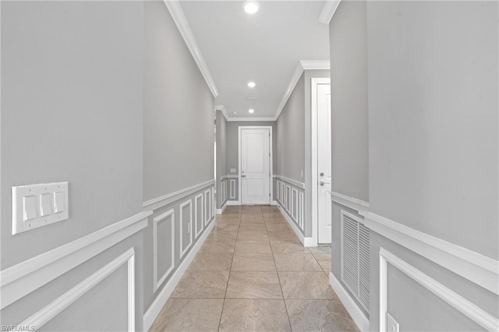 19953 Beverly Park Road Estero, FL 33928 - Photo 4 of 50 Hallway featuring visible vents, recessed lighting, ornamental molding, wainscoting, and a decorative wall
