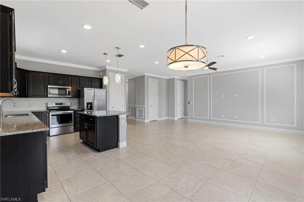 19953 Beverly Park Road Estero, FL 33928 - Photo 7 of 50 Kitchen featuring visible vents, decorative backsplash, appliances with stainless steel finishes, a decorative wall, and a sink