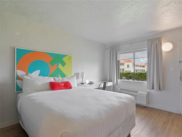 a bedroom with a bed and a large window