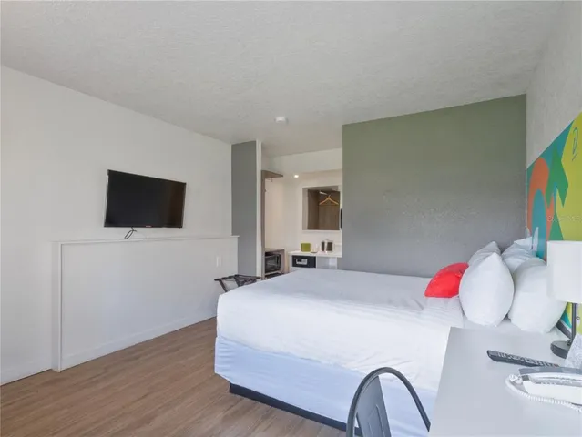 a bedroom with a bed and a flat screen tv