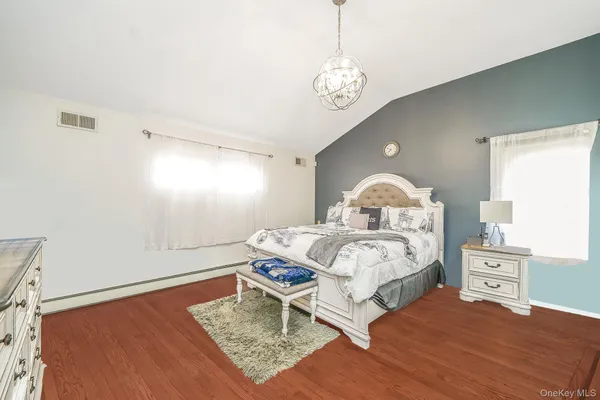 a spacious bedroom with a bed and a dresser