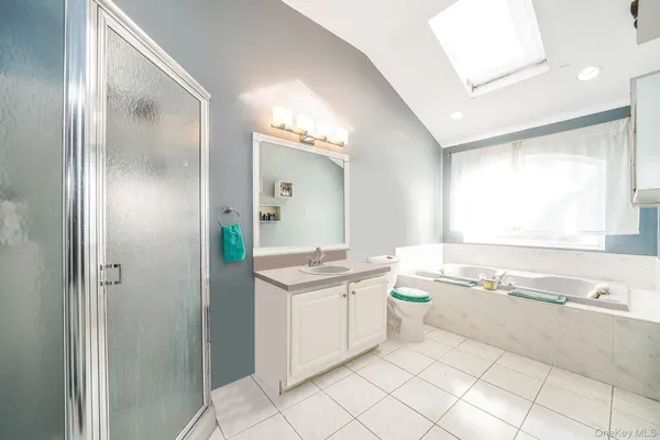 a bathroom with a granite countertop sink mirror and bathtub