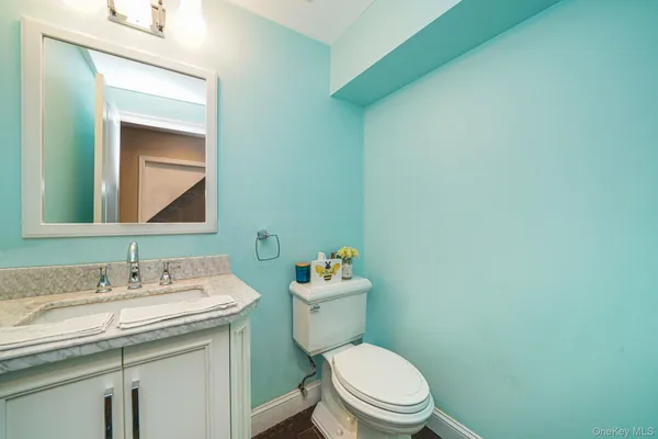 a bathroom with a toilet sink vanity and mirror