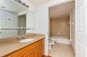 4242 Northwest 2nd Street, Unit 1012 Miami, FL 33126 - Photo 11 of 17 a bathroom with a granite countertop sink a toilet and a shower