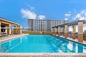 4242 Northwest 2nd Street, Unit 1012 Miami, FL 33126 - Photo 15 of 17 a view of a kitchen with kitchen island and a large window