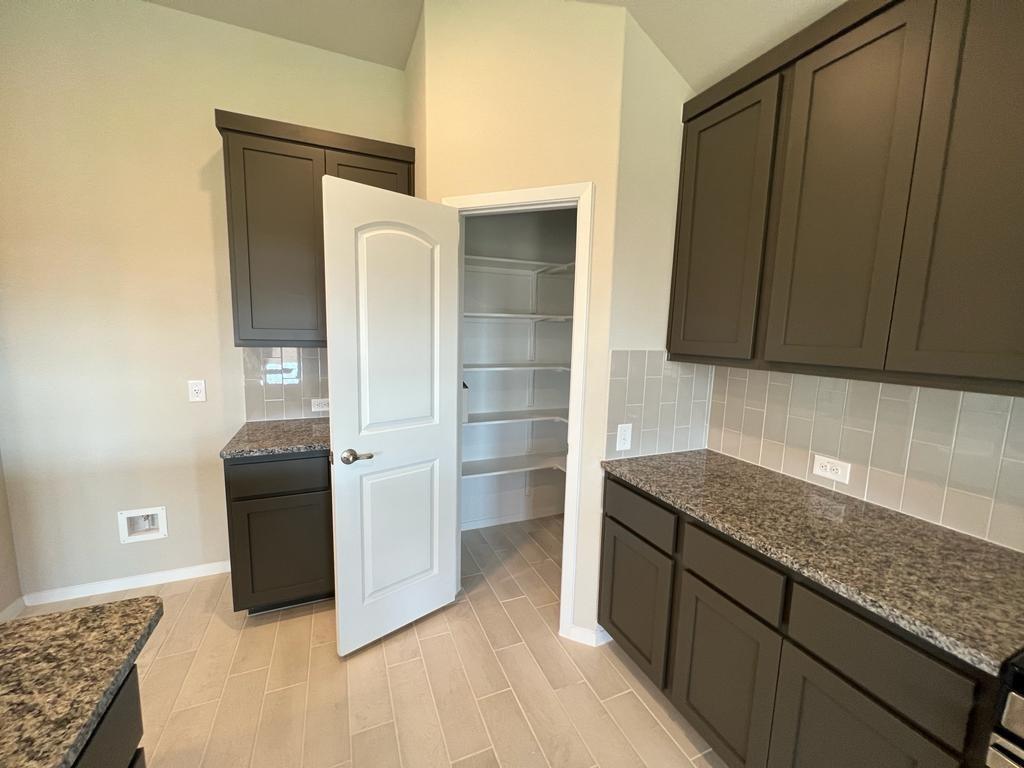 105 Spiny Lizard Lane San Marcos, TX 78666 - Photo 21 of 34 Kitchen with dark stone countertops, backsplash, and wood tiled floors