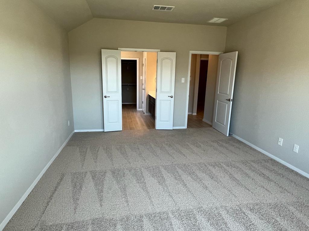 105 Spiny Lizard Lane San Marcos, TX 78666 - Photo 6 of 34 Unfurnished bedroom with light carpet and vaulted ceiling