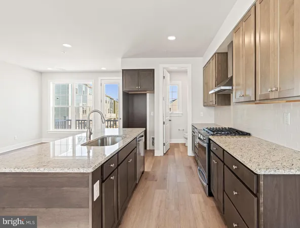 a kitchen with granite countertop a sink a counter top space stainless steel appliances and cabinets