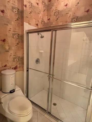 a white toilet sitting next to a shower