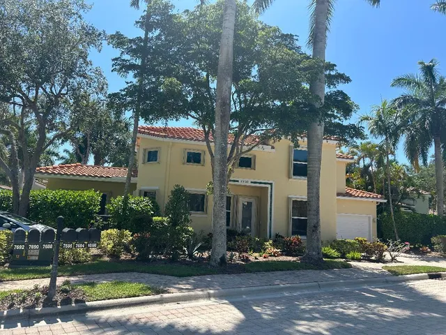 a view of a white house with a yard and plants