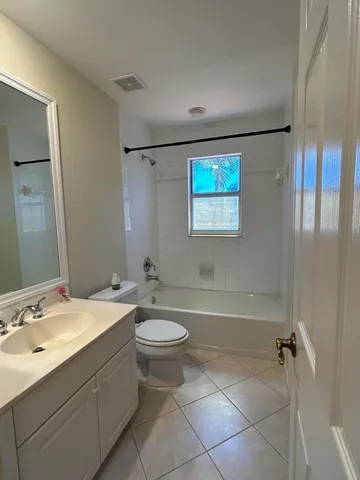 a bathroom with a double vanity sink toilet mirror and bathtub