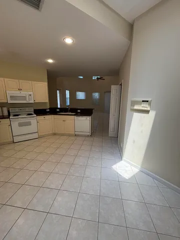 a large kitchen with stainless steel appliances a large counter top and a stove top oven