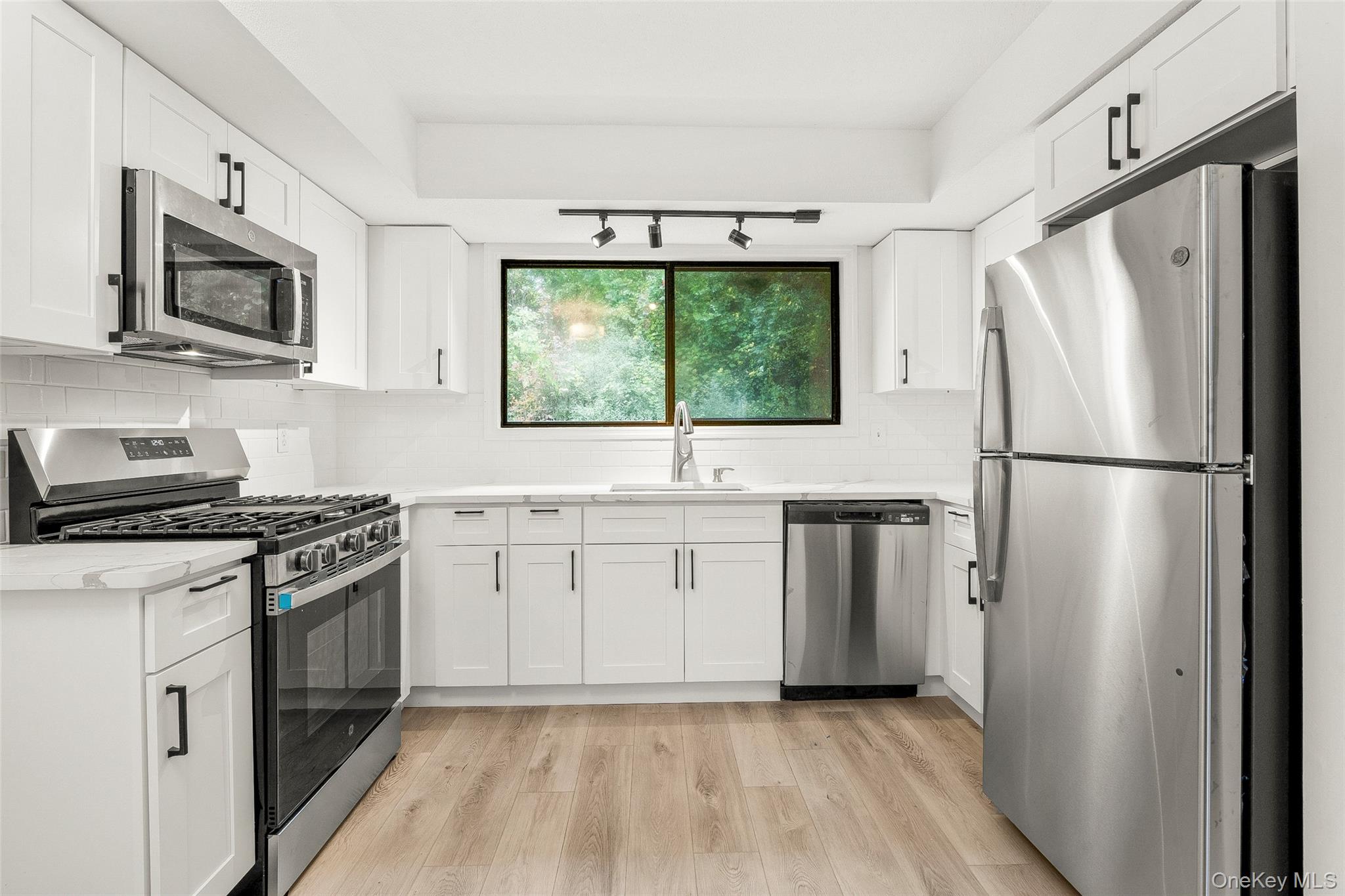 25 Laurel Court Fishkill, NY 12524 - Photo 4 of 26 a kitchen with white cabinets stainless steel appliances and a window