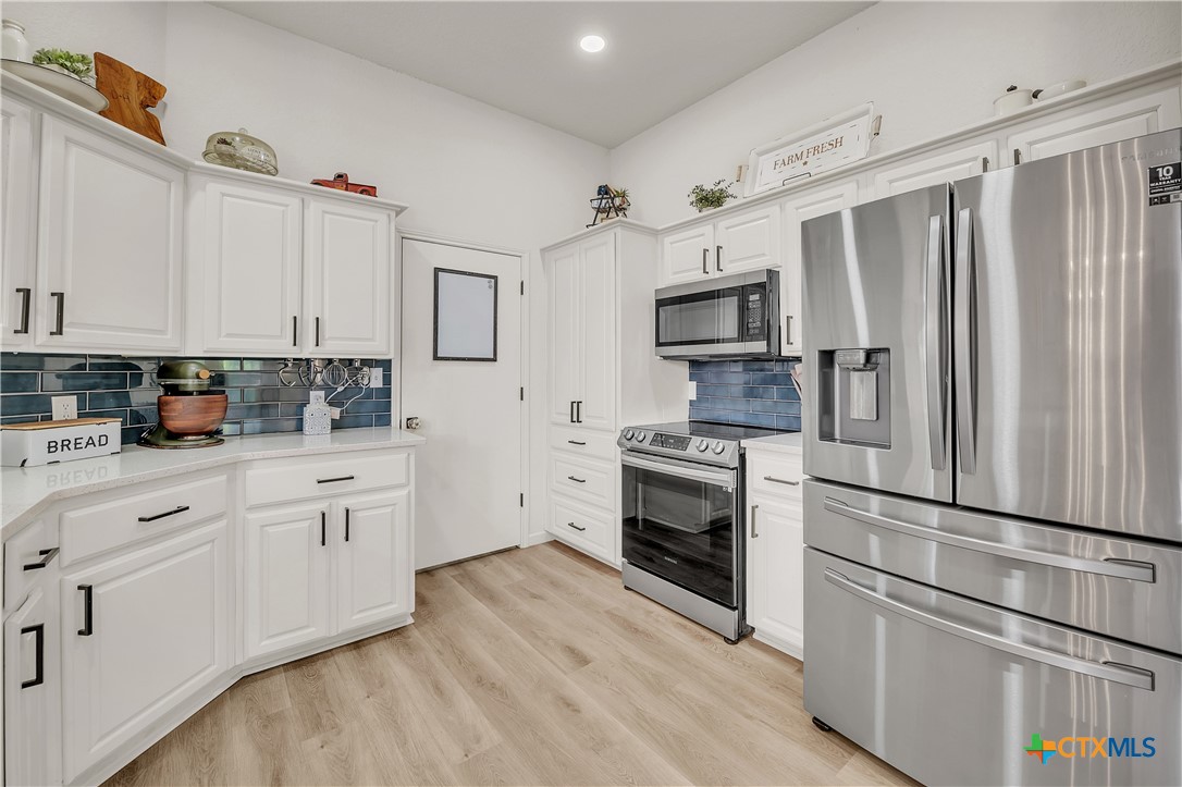 3905 Tyler Trail Temple, TX 76504 - Photo 20 of 31 a kitchen with cabinets stainless steel appliances and wooden floor