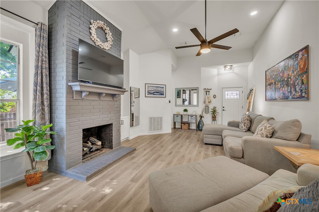 3905 Tyler Trail Temple, TX 76504 - Photo 7 of 31 a living room with furniture a flat screen tv and a fireplace