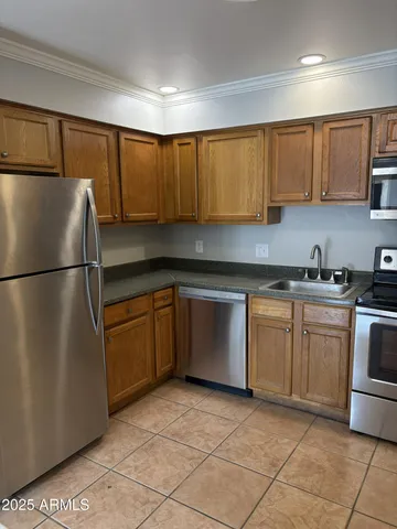 a kitchen with a refrigerator sink and cabinets