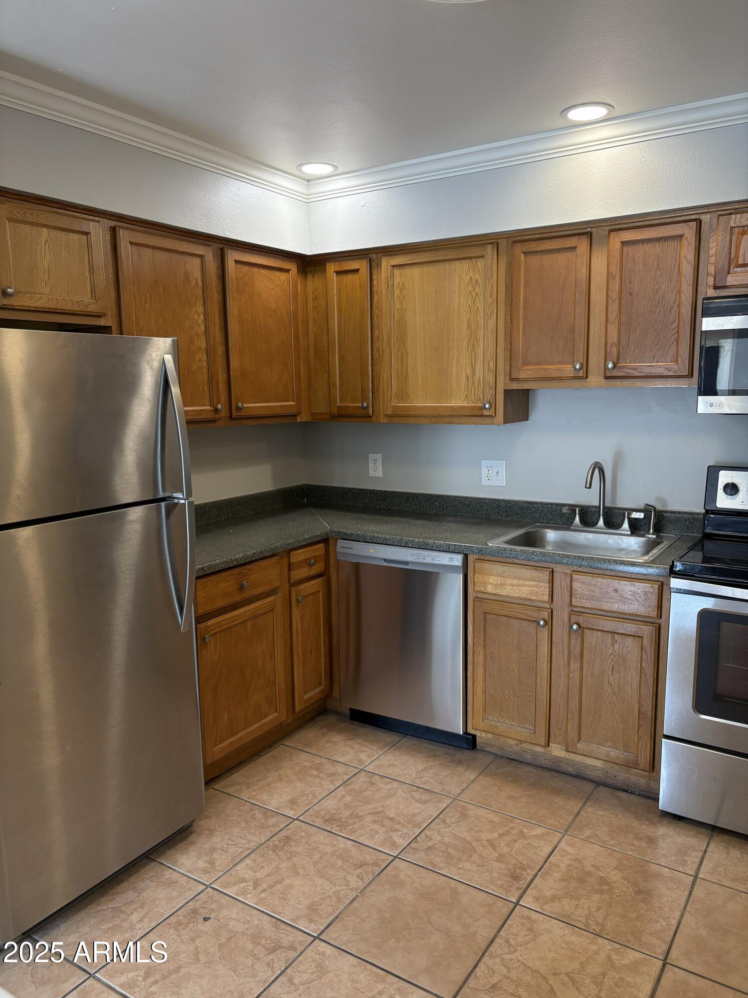 909 South Priest Drive, Unit 10 Tempe, AZ 85281 - Photo 2 of 14 a kitchen with a refrigerator sink and cabinets