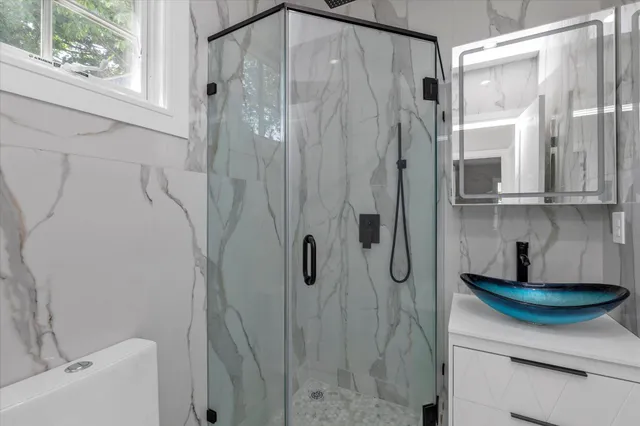 a bathroom with a sink a mirror and shower