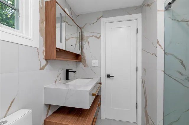 a bathroom with a sink a toilet and shower