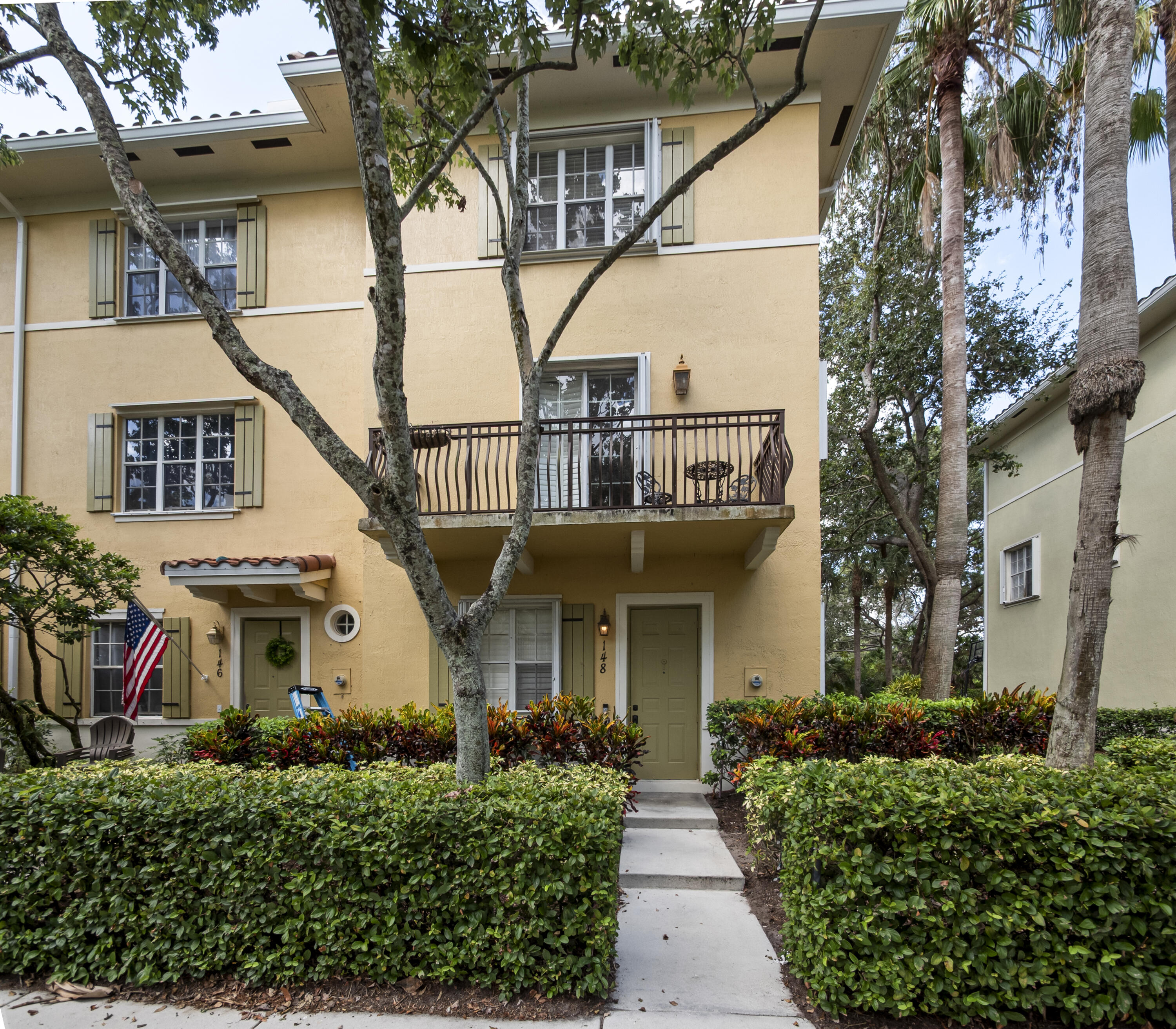 a front view of a house with a tree