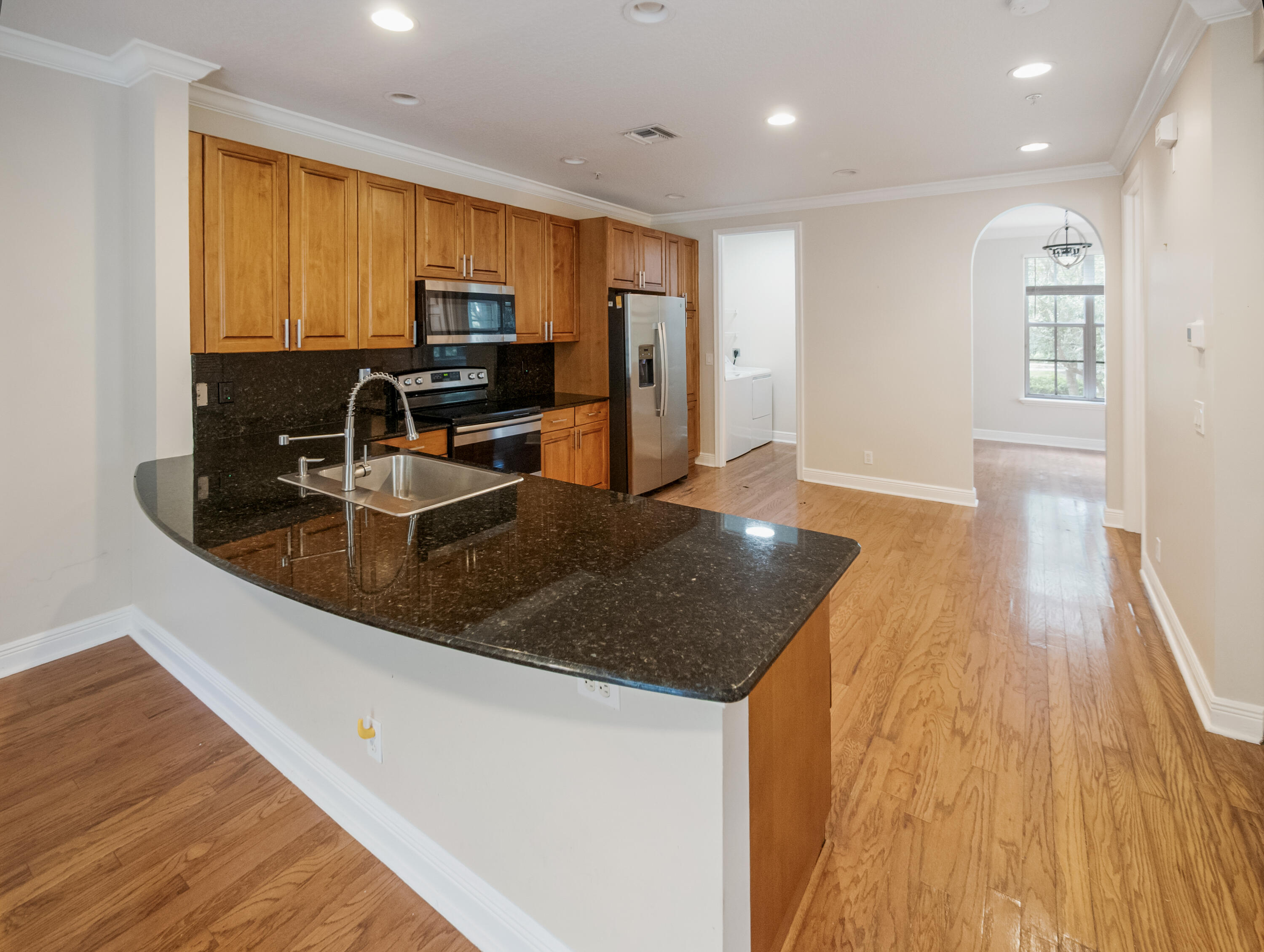 148 Morning Dew Circle Jupiter, FL 33458 - Photo 2 of 21 a kitchen with stainless steel appliances granite countertop a sink a stove counter space and wooden floor