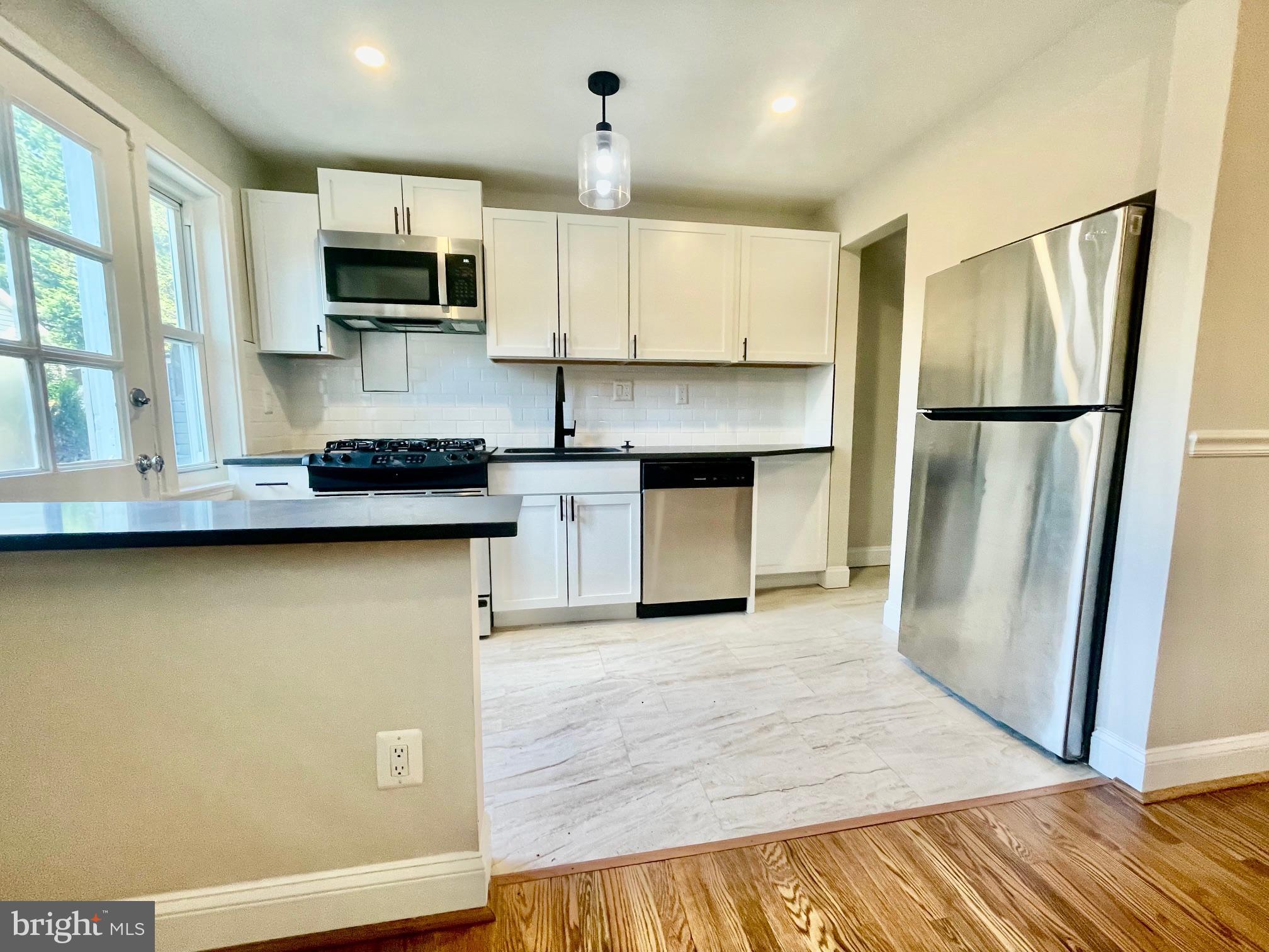 2809 A 16th Road South, Unit 2809A Arlington, VA 22204 - Photo 8 of 13 a kitchen with stainless steel appliances granite countertop a refrigerator a stove top oven a sink and dishwasher