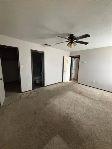a view of a livingroom with a ceiling fan and carpet