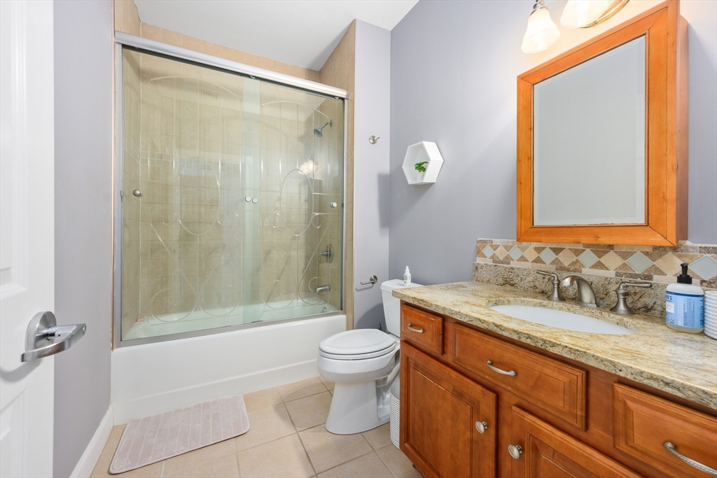 68 Center Street, Unit 13 Barnstable, MA 02601 - Photo 14 of 29 a bathroom with a granite countertop sink toilet and shower