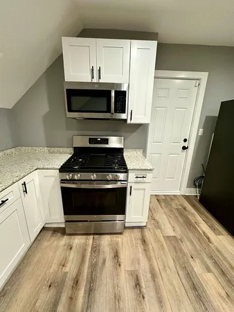 a kitchen with granite countertop a stove and a microwave