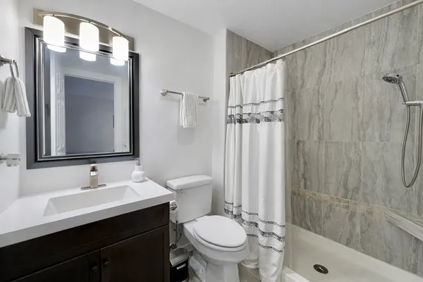 a bathroom with a sink a toilet and shower
