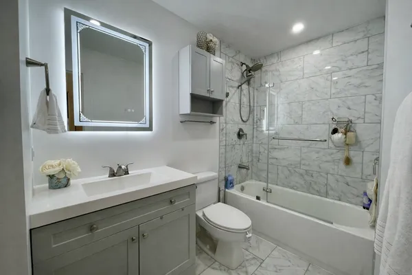 a bathroom with a sink a toilet and shower