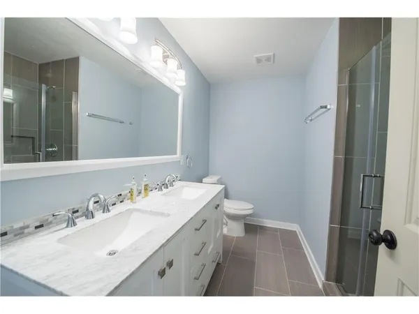 a bathroom with a sink vanity granite and toilet