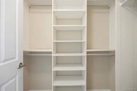 a view of walk in closet with empty racks