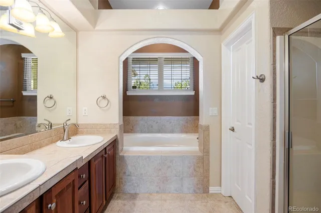 a bathroom with a granite countertop bathtub sink vanity and mirror