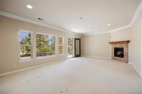 a view of an empty room with a window and a fireplace