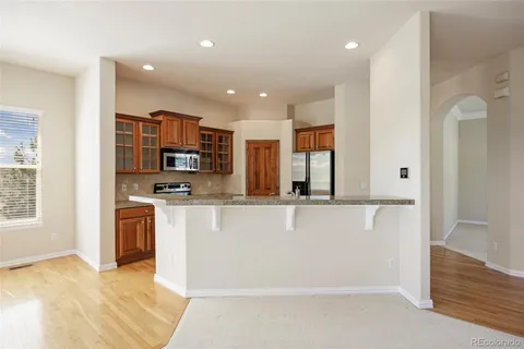 a view of kitchen with stainless steel appliances cabinets and empty room