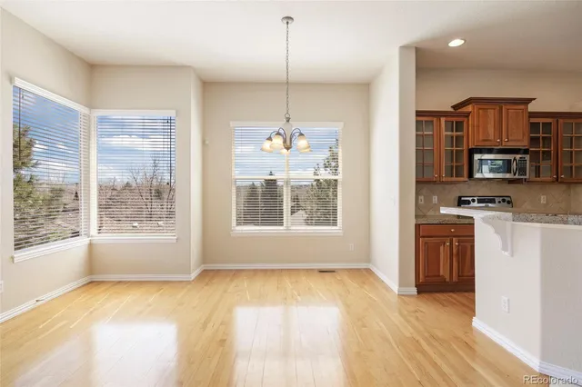 a kitchen with a refrigerator a stove top oven a sink and dishwasher with wooden floor