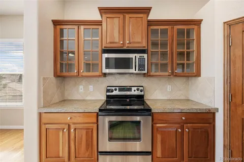 a kitchen with granite countertop a stove top oven cabinetry a sink and dishwasher