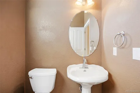 a bathroom with a toilet a sink and a mirror