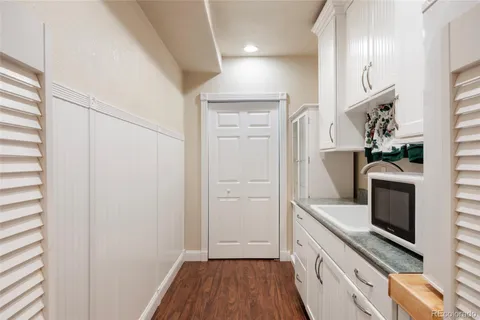 a kitchen with cabinets and wooden floor