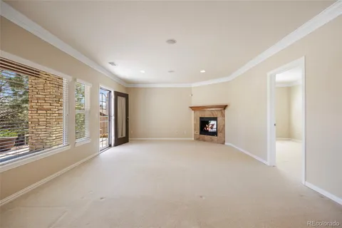a view of an empty room with a fireplace and a window