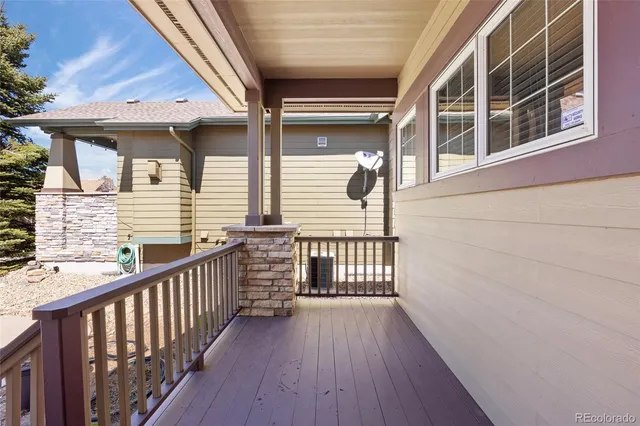 a view of a balcony with wooden floor and fence