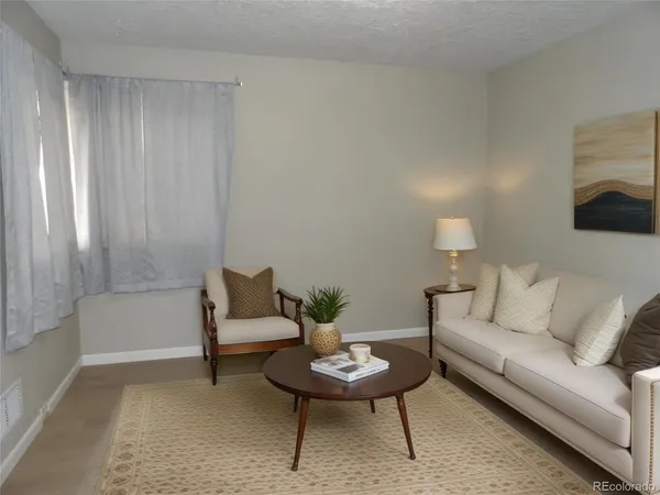 a living room with furniture and a potted plant