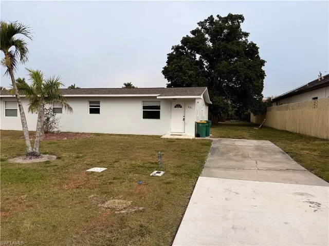 a backyard of a house with table and chairs